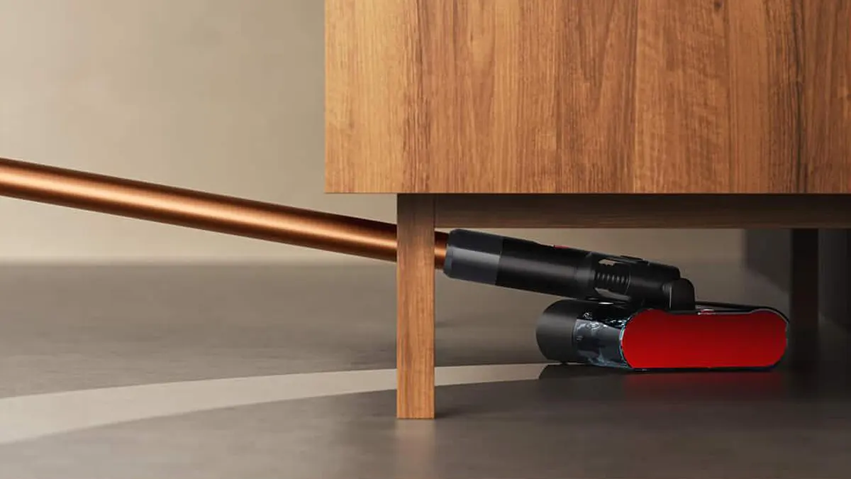 Der Dyson PencilWash saugt und wischt unter einem Sideboard.