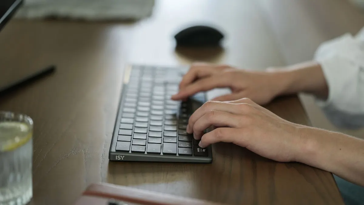 Zwei Hände tippen auf der Tastatur ISY IKE-7100.