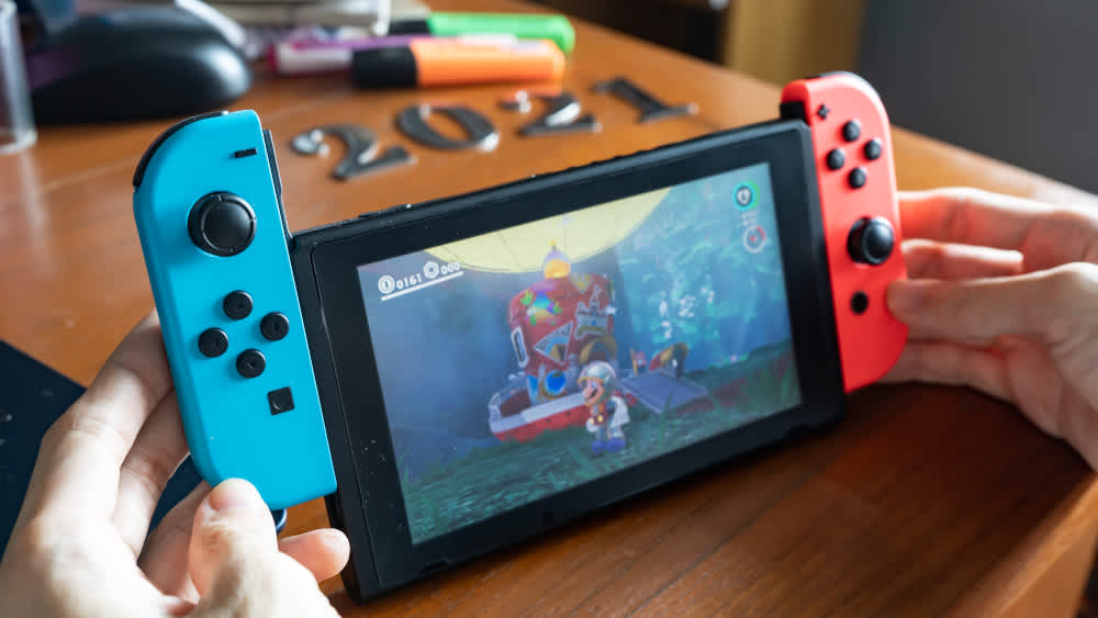 Eine Person schiebt die Joy-Con-Controller aus der Nintendo Switch.