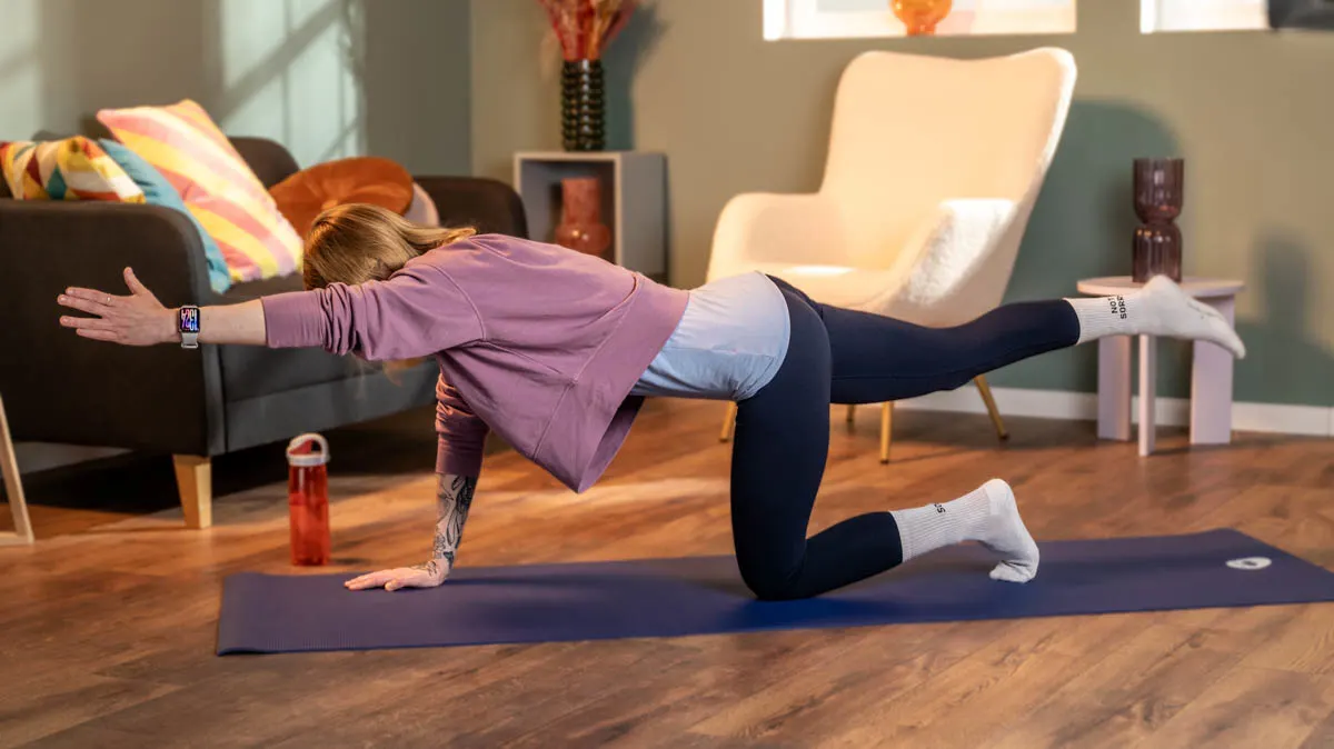 Franzi trägt das Xiaomi Smart Band 9 Pro und macht eine Rückenübung auf einer Yogamatte.