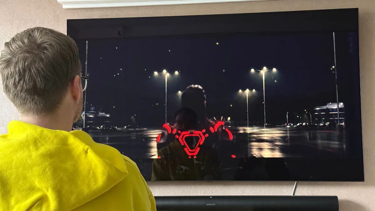 Michael sitzt vor Fernseher und Soundbar und sieht sich einen Film an.