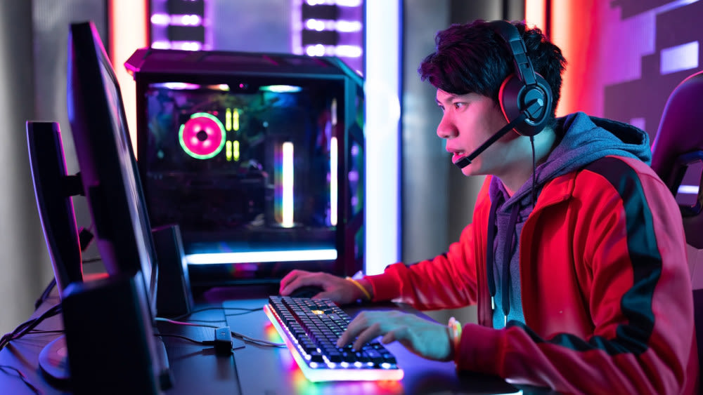 Ein Mann spielt mit einer Gaming-Tastatur am PC.