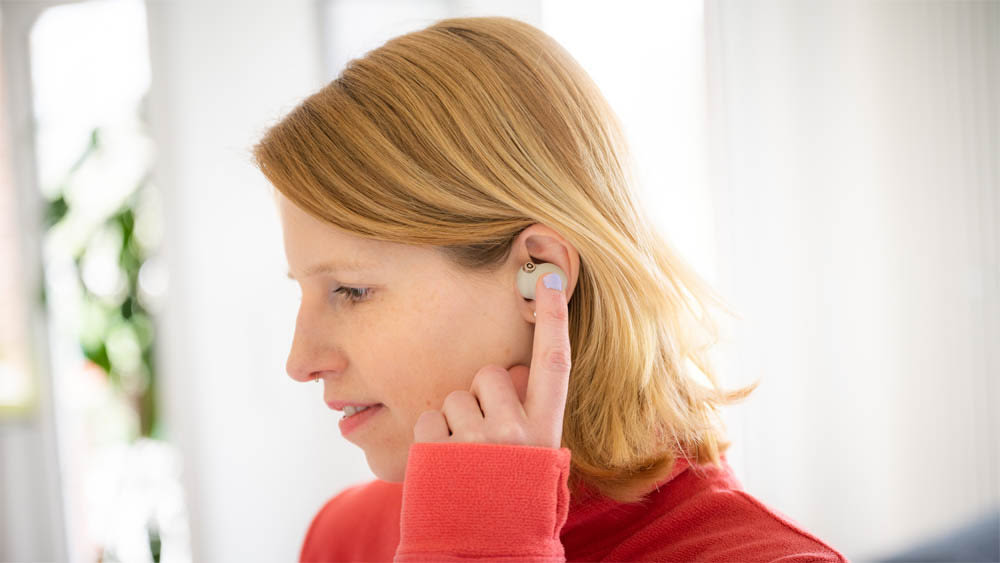 Franzi trägt die Sony-WF-1000-XM4-Noise-Cancelling-Kopfhörer und bedient sie per Fingertipp.