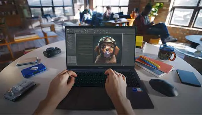 Ego-Perspektive eines Mannes, der vor seinem Laptop sitzt. Auf dem Bildschirm ist ein Fotobearbeitungsprogramm zu sehen.