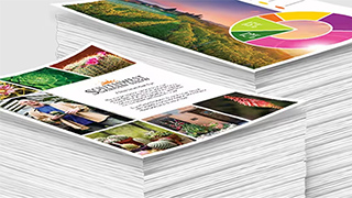 Stapel von bedruckten Blättern Papier, die verschiedene Layouts, Grafiken und fotografische Elemente präsentieren.