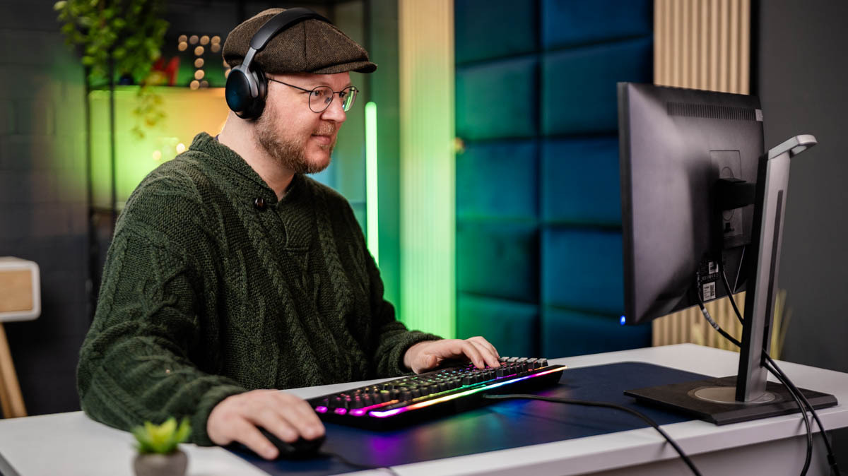 Andreas spielt mit einer leuchtenden mechanischen Tastatur ein PC-Spiel.
