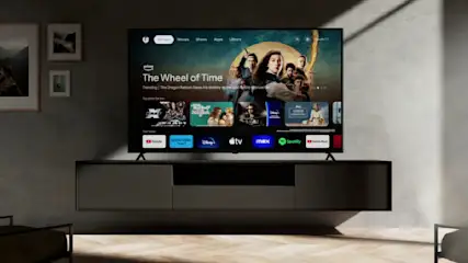 Ein PEAQ PTV 65GQU-5024C Fernseher steht in einem Wohnzimmer.