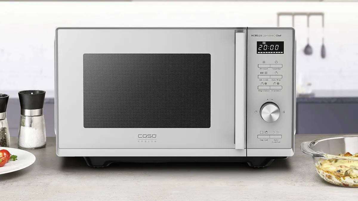 Die Mikrowelle Caso HCMG 25 Ceramic Chef steht in einer hellen Küche auf einem Tisch.