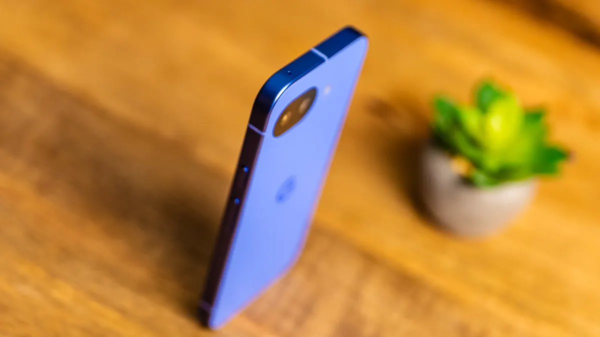 Das Pixel 10a steht auf einem Holztisch, man sieht es von schräg oben.