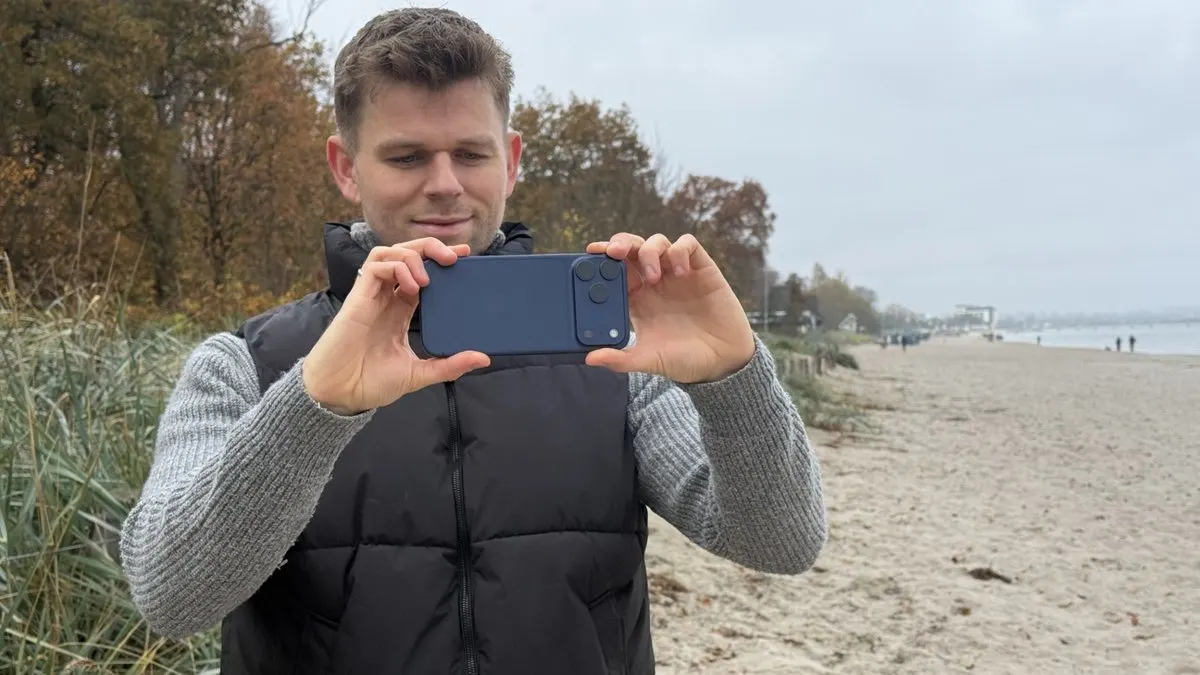 Niklas macht mit dem iPhone 17 Pro Max ein Foto am Strand.