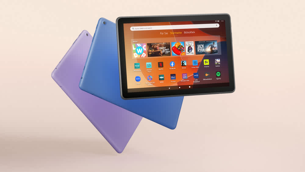 Drei Amazon-Fire-HD-10-Tablets in unterschiedlichen Farben schweben vor beigefarbenem Hintergrund.