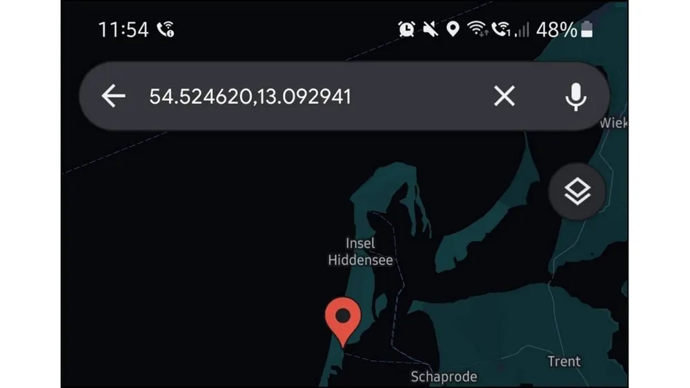 Handy-Display mit Kartenausschnitt der Insel Hiddensee, roter Positionsmarkierung und Koordinaten 54.524620, 13.092941 in Suchleiste.
