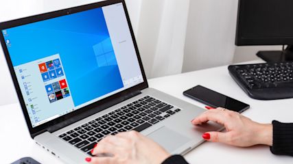 Weibliche Hände auf einer Laptoptastatur