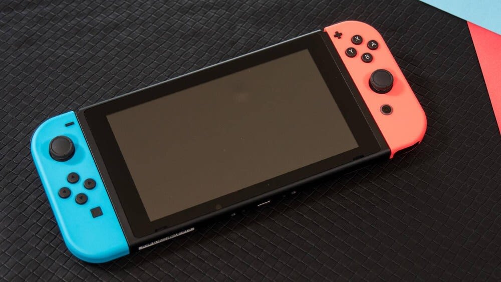 Eine Nintendo Switch liegt auf einer schwarzen Oberfläche.