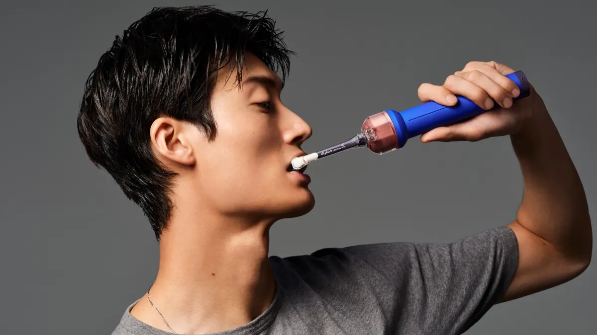 Ein Mann putzt sich mit der Dyson CameraJet die Zähne.