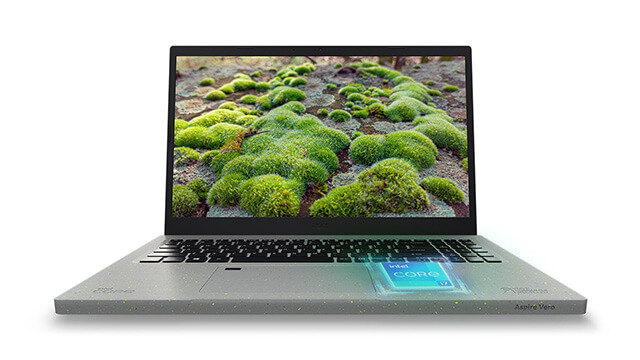 Ein Notebook mit schwarzer Tastatur und einem Bildschirm, der moosbedeckten Boden zeigt, steht auf einem weißen Hintergrund.