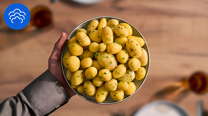 Dampfgegarte Kartoffeln auf einem Teller. In der Ecke ist ein Dampfgar-Icon abgebildet.