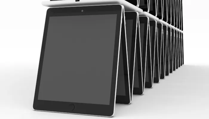 Auf einem weißen Untergrund stehen viele iPads wie ein Kartenhaus gestapelt.