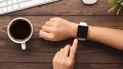 Eine Person hält den Zeigefinger auf dem Display einer Apple Watch.