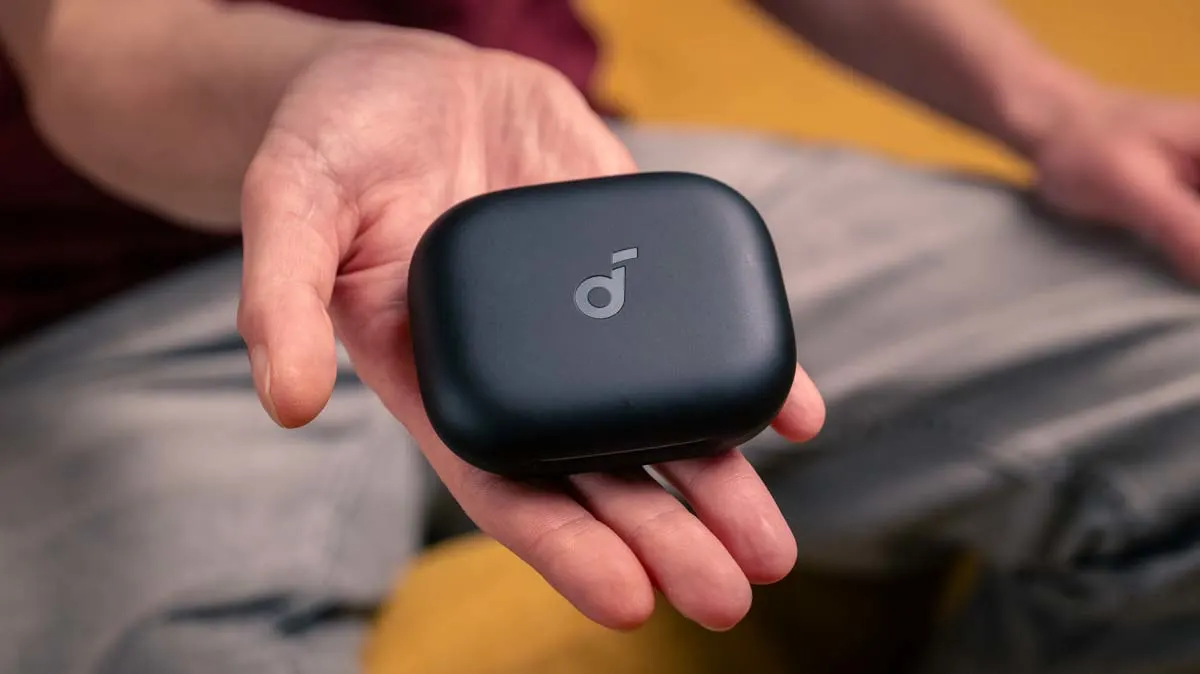 Alex zeigt das Ladecase der Open-Ear-Kopfhörer Soundcore Aerofit 2 in die Kamera.