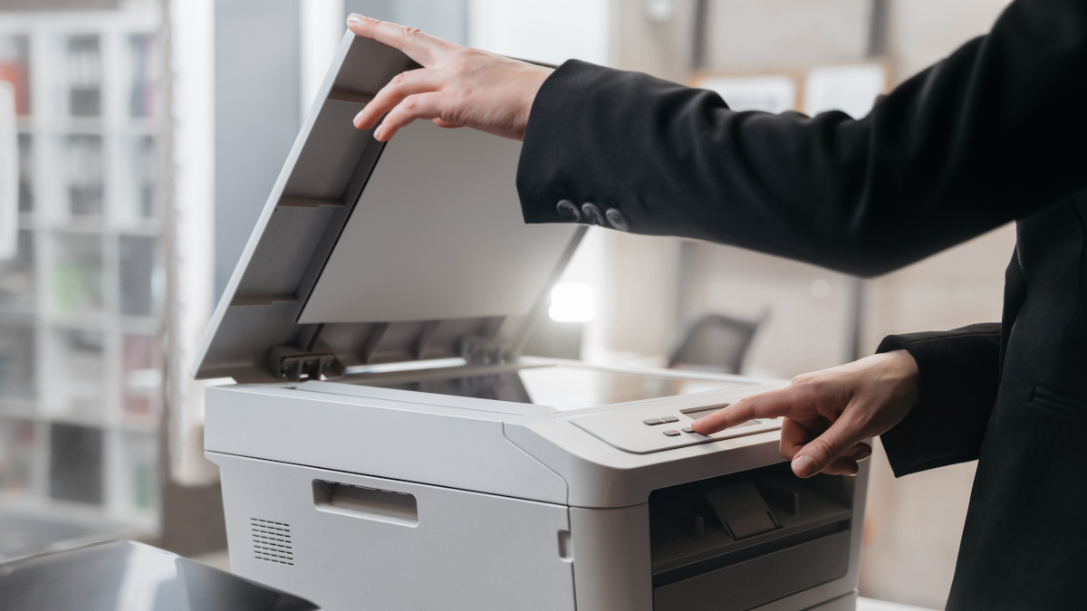 Eine Person bedient einen Laserdrucker. 