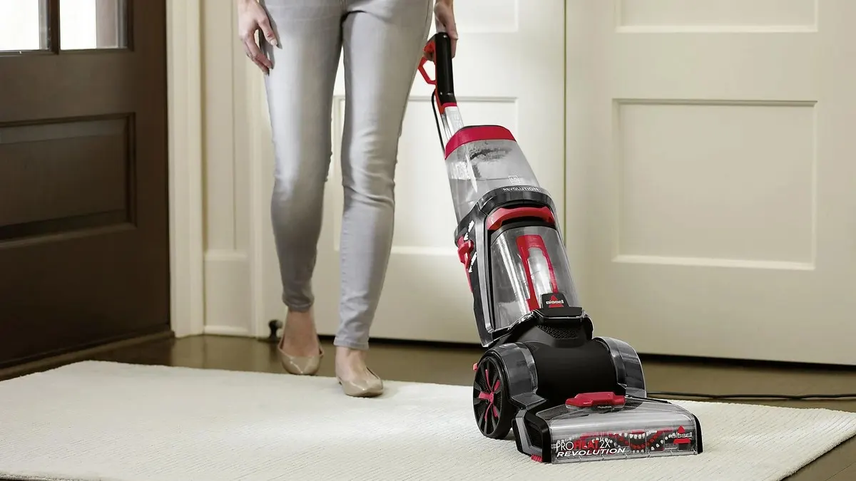Eine Frau reinigt einen Teppich mit dem Bissell ProHeat 2X Revolution.