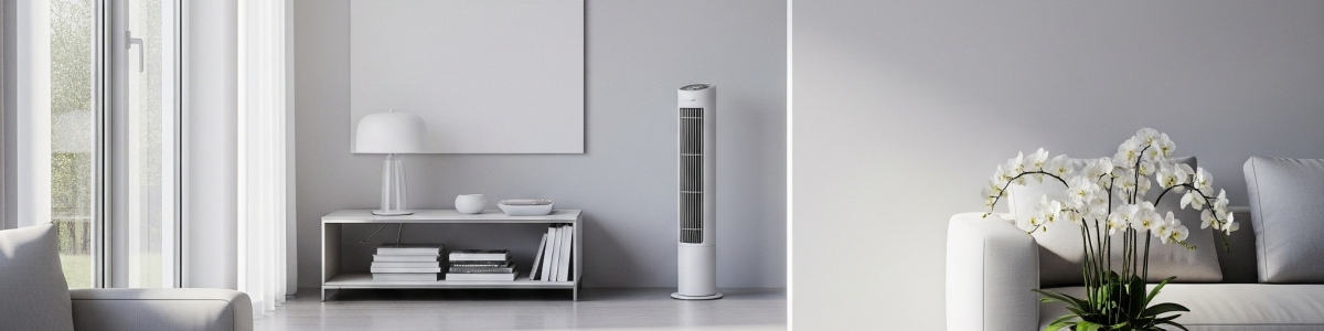 Jasne wnętrze. Widok na okno z zasłonami, regał z książkami, lampę, najlepszy wentylator kolumnowy i sofę z kwiatami. Stonowana kolorystyka.