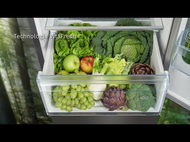 Otwarta szuflada lodówki wypełniona różnymi warzywami i owocami, w tym sałatą, kapustą, jabłkami, winogronami i karczochami.