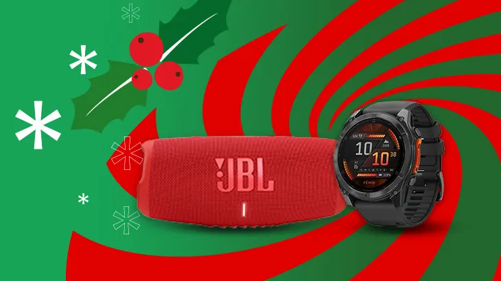 Na zielono-czerwonym tle widoczny jest czerwony głośnik JBL i czarny zegarek sportowy Garmin, obok gałązka ostrokrzewu i śnieżynki.