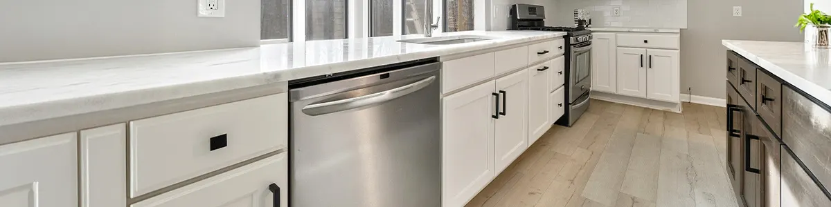 Nowoczesna zmywarka wolnostojąca pod białym blatem w eleganckiej kuchni