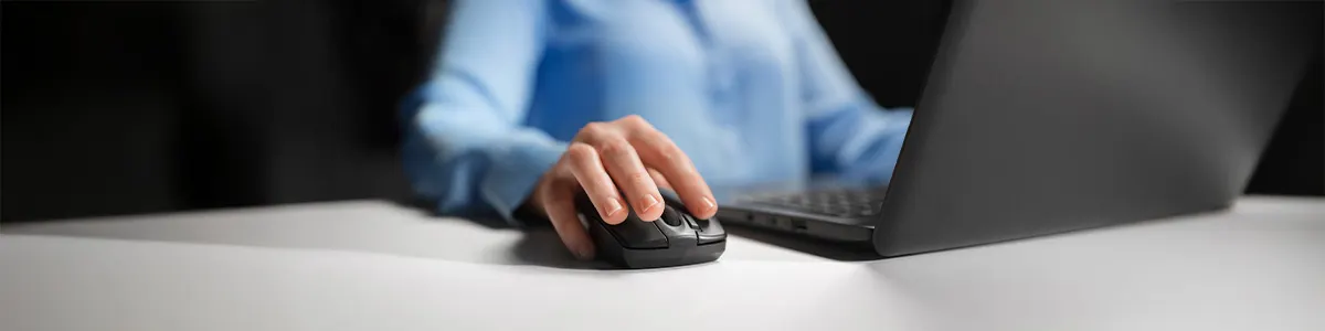 Prosta czarna myszka biurowa podczas pracy. Prowadzi ją męska dłoń.