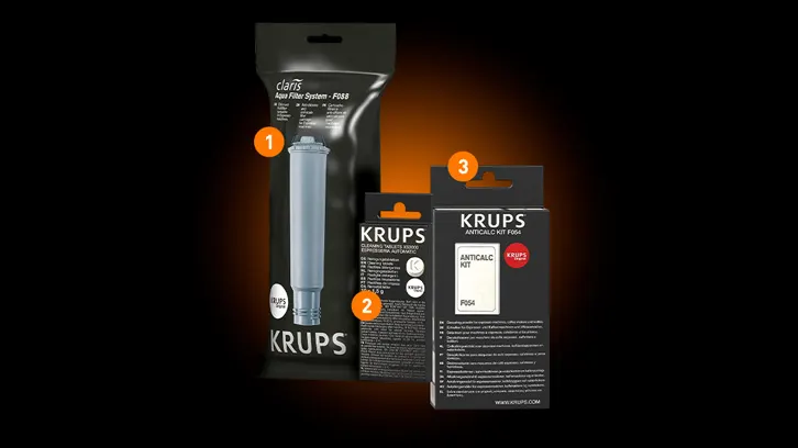Na czarnym tle widoczne są trzy opakowania produktów Krups: filtr do wody w folii, zestaw do czyszczenia i odkamieniacz w pudełkach.