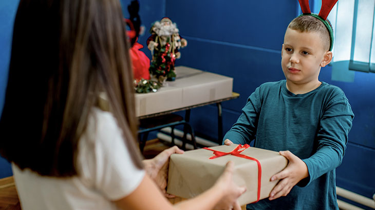 Chłopiec i dziewczynka wręczają sobie prezent w szkole.