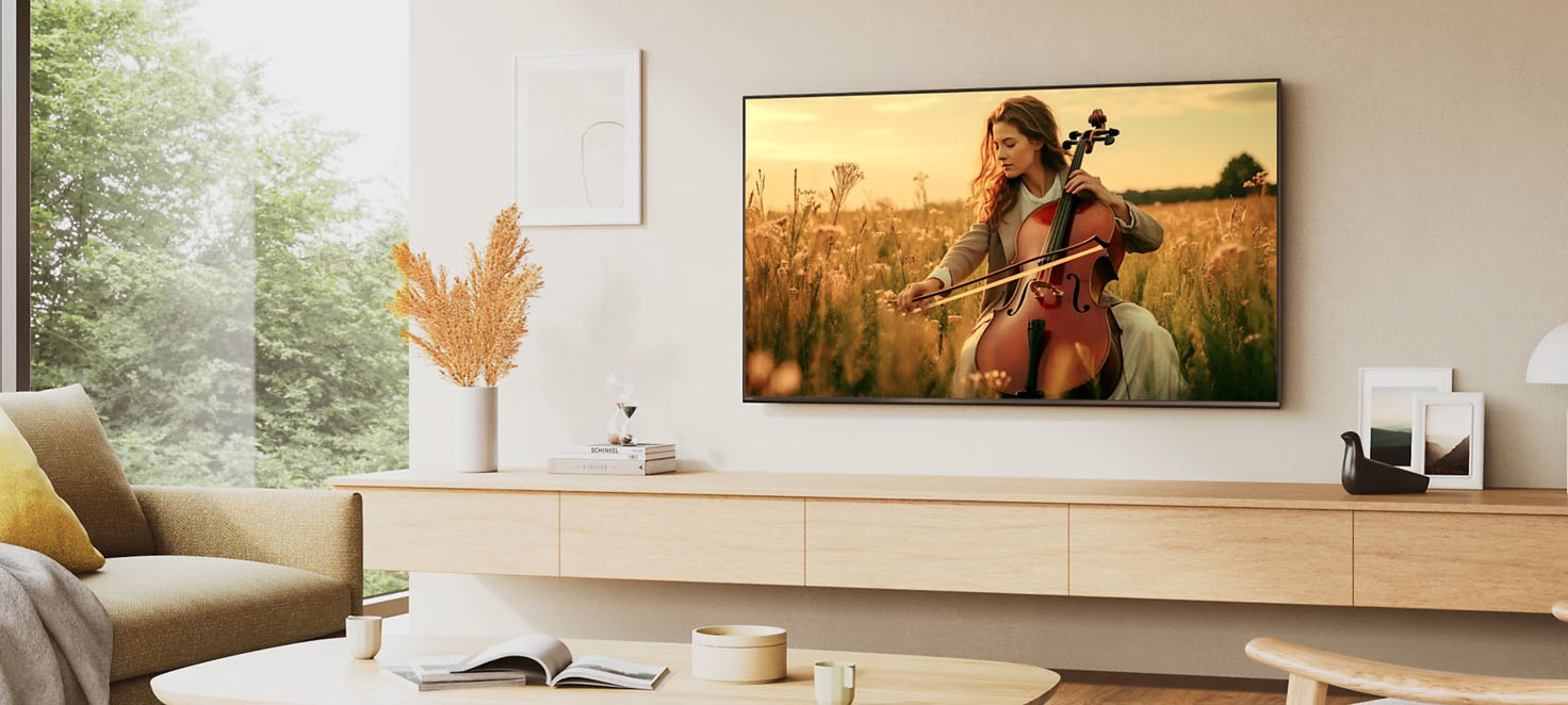 Zdjęcie przedstawiające salon, a na telewizorze widnieje kobieta grająca na wiolonczeli