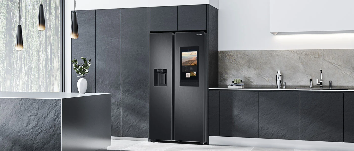 Kuchnia z szarymi szafkami, lodówką Samsung z ekranem i wyspą. Wiszą lampy.