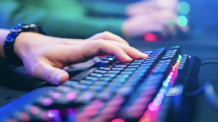 Ręka klika w klawiaturze, na nadgarstku zegarek