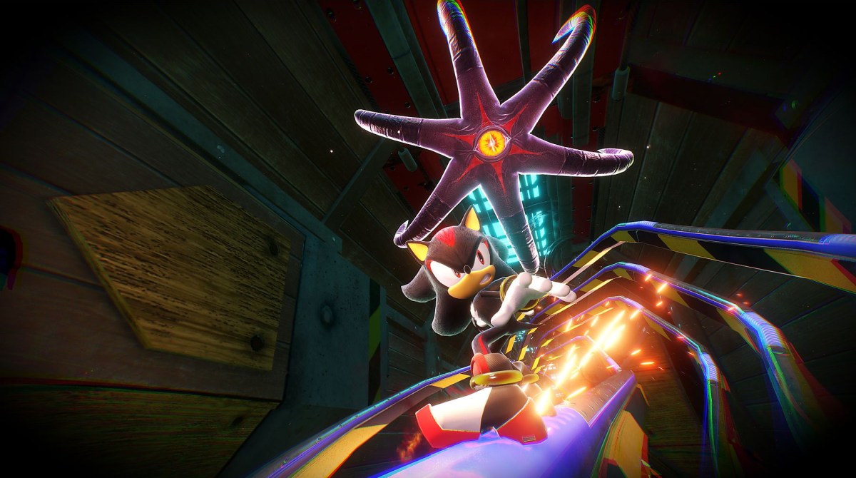 Na torze Shadow the Hedgehog, nad nim ciemna gwiazda z żółtym okiem. W tle metalowa konstrukcja.