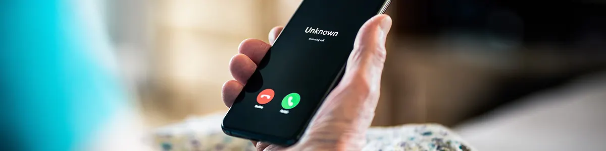 Mężczyzna z telefonem w ręce z połączeniem z zastrzeżonego numeru.