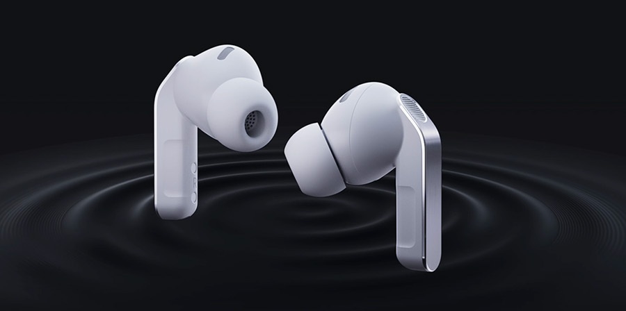 Dwie białe słuchawki dokanałowe buds4 pro unoszące się nad ciemnym tłem, skierowane ku sobie; silikonowe końcówki i srebrne wstawki na trzonkach, pod nimi koncentryczne fale dźwięku.