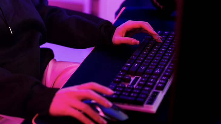 Osoba klika w klawiaturę i używa myszki