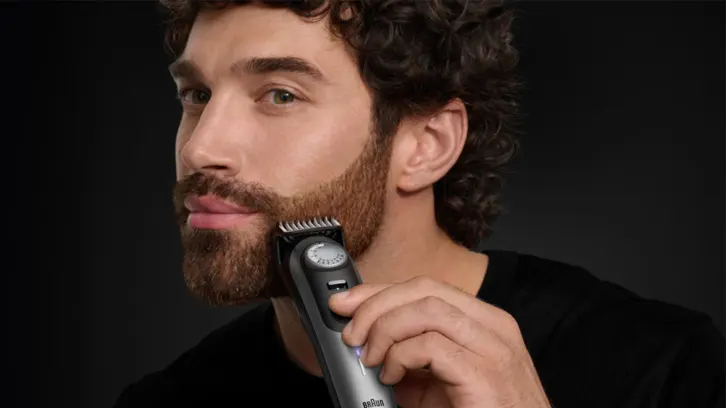 Mężczyzna golący brodę golarką Braun