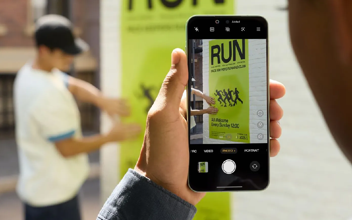 rozmyte tło jak mężczyzna przykleja plakat na ściane. Wyraźny obraz w smartfonie 