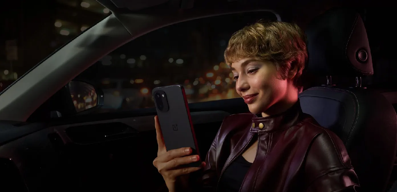 kobieta przeglądająca telefon siedząca w samochodzie, na ciemnym tle