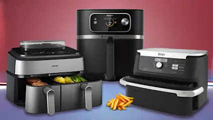 Zdjęcie przedstawia trzy frytkownice, frytki i pomidory na czerwonym tle. Frytkownice są czarne i srebrne. Frytki są żółte. Pomidory są czerwone.