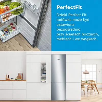 Lodówka srebrna obok białych szafek kuchennych, z otwartymi szufladami pełnymi warzyw. Na blacie kuchennym naczynia i deska.