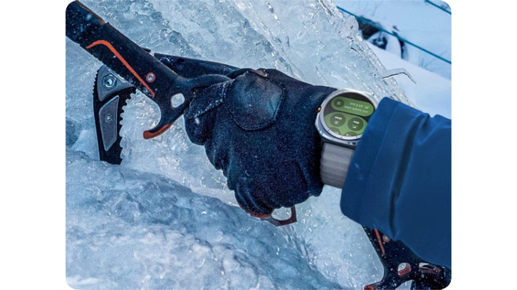 Ręka trzymająca czekan, wbijany w krawędź góry podczas wspinaczki. Na nadgarstku widoczny zegarek Samsung Galaxy Watch Ultra.
