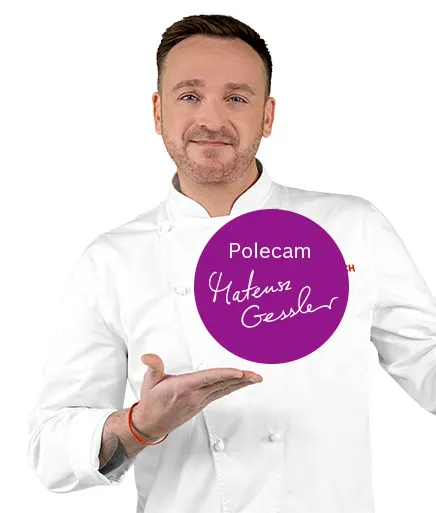 Mężczyzna w białym fartuchu kucharskim prezentuje fioletowe koło z tekstem "Polecam Mateusz Gessler". Ma czerwoną bransoletkę.