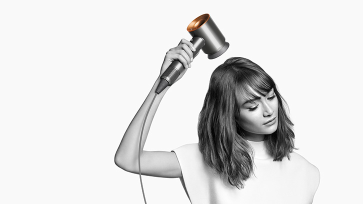 Modelka używająca suszarki do włosów