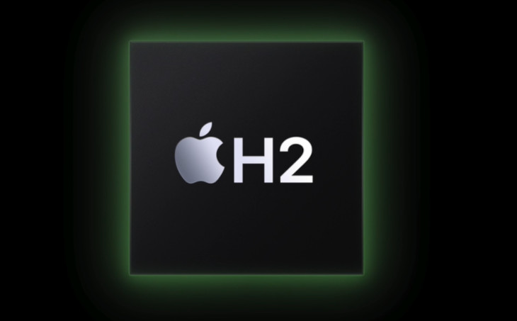 Czarny kwadrat z zieloną obwódką. Wewnątrz, srebrne logo Apple i biały napis „H2”.