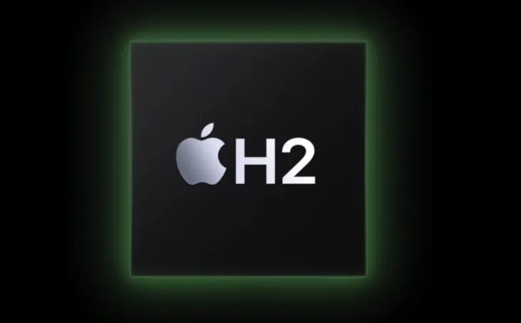Czarny kwadrat z zieloną obwódką. Wewnątrz, srebrne logo Apple i biały napis „H2”.